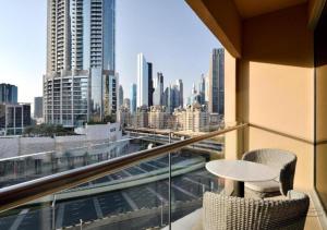 a balcony with a table and chairs and a view of a city at Deluxe - Address Dubai Mall - The Residence in Dubai