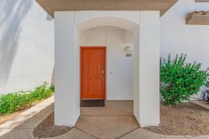 a hallway with a red door in a white house at Miller Road 207A townhouse in Scottsdale