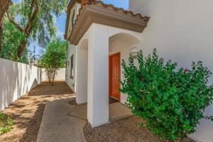 an entrance to a white house with a plant at Miller Road 207A townhouse in Scottsdale