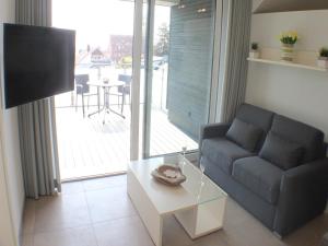 a living room with a couch and a table at Sonnengarten 21 in Kellenhusen