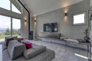 un soggiorno con divano, TV e finestre di Chalet Panorama a Freyung