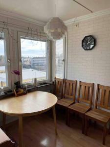 a dining room with a table and chairs and a clock at Sunny ROOM in Stockholm in Stockholm