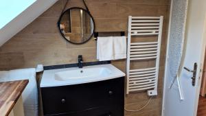 a bathroom with a sink and a mirror at La Cigogne in Château-Thierry