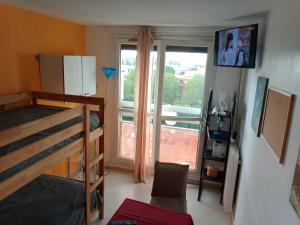 1 dormitorio con litera y ventana grande en Room in Guest room - Chambre dhote sur ParisPantin en Pantin