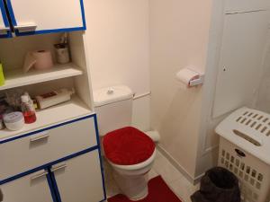 a small bathroom with a toilet with a red seat at Room in Guest room - Chambre dhote sur ParisPantin in Pantin