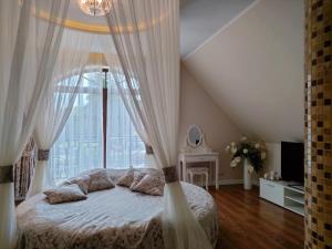 una camera da letto con un letto con tende e una finestra di Hotel Viwaldi a Baruchowo