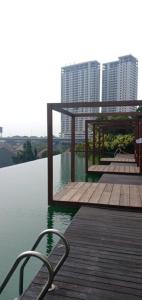 um deque de madeira com uma mesa e cadeiras sobre a água em sewa apartment Lagoon BY Room911 em Pulosirih