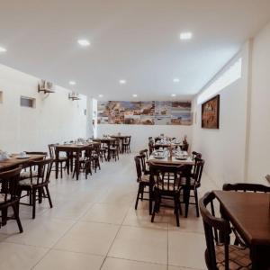 a dining room with wooden tables and chairs at Happy Hotel Brisa do Mar in Ipojuca