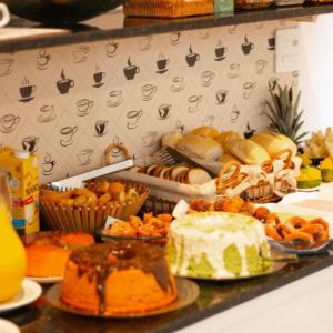 a table topped with lots of different types of food at Happy Hotel Brisa do Mar in Ipojuca