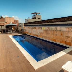 a swimming pool on the side of a building at Happy Hotel Brisa do Mar in Ipojuca