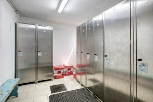 una fila de taquillas de metal en un baño con banco en Appartamento Bormetti Paolo Sara en Livigno