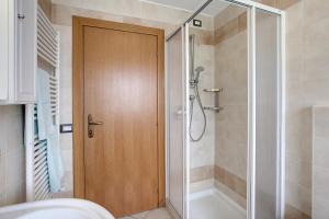 y baño con ducha y puerta de madera. en Appartamento Bormetti Paolo Sara, en Livigno 33 fotos más