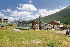 um campo com uma casa no meio de uma montanha em Appartamento Bormetti Paolo Sara em Livigno