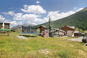 a field with a house in the middle of a mountain at Appartamento Bormetti Paolo Sara in Livigno