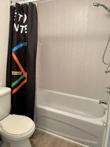 y baño con aseo, bañera y ducha. en Chez Sarah: Montreal themed cozy loft, en Montreal