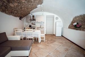 a living room with a table and a kitchen at Corte Isabel in Costermano