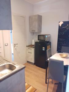 a small kitchen with a black refrigerator and a table at Casa Vacanze MURANUM - B&B in Morano Calabro