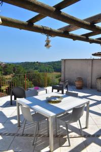 una mesa blanca y sillas en un patio en Casa Macina, en CastellʼAlfero