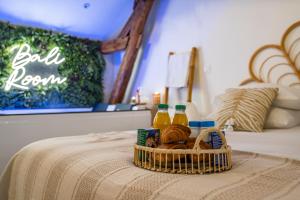 a basket of bread and juice on a bed at BALI ROOM / Magnifique studio évasion JACCUZI in Montgeron