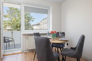 a dining room with a table and chairs at Źródlana Two-Bedroom Apartment with Balcony Kołobrzeg by Renters in Kołobrzeg