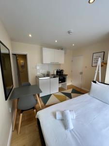 a bedroom with a bed and a desk and a kitchen at Flat 1, 128A Belsize Road NW6 4BG LONDON in London