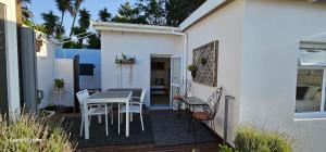 a patio with a table and chairs on a deck at Parsons Hill Apartment in Glendinningvale