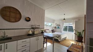 a kitchen with a table and a bed in a room at Parsons Hill Apartment in Glendinningvale +23 photos