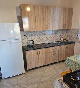 a kitchen with a white refrigerator and a sink at Guest house Lagodehki 