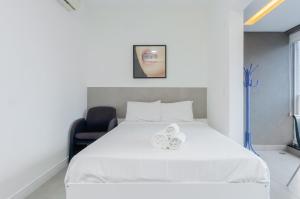 sypialnia z białym łóżkiem i krzesłem w obiekcie 360 Perdizes w São Paulo
