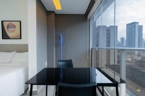 a black table and chairs in a room with a window at 360 Perdizes in São Paulo