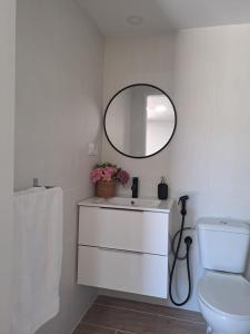 een witte badkamer met een wastafel en een spiegel bij O Peteiro in Redondela