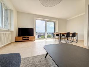 a living room with a television and a table and chairs at Minven in Concarneau