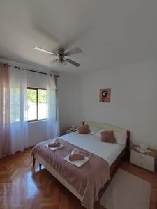 Schlafzimmer mit einem Bett und einem Deckenventilator in der Unterkunft Apartment Marta in Jablanac