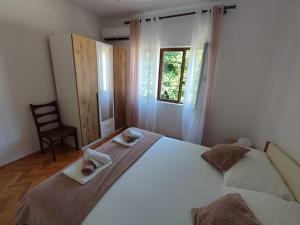 a bedroom with a bed with two towels and a chair at Apartment Marta in Jablanac