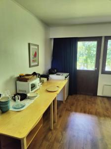 - une cuisine avec une table en bois et un four micro-ondes dans l'établissement Jokirannan Majoitus, à Kokemäki