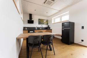 a kitchen with a wooden table and black refrigerator at Aparthotel nah dran in Dingolfing