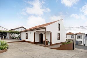 biały dom z dziedzińcem z przodu w obiekcie Casa das Rosas w mieście Angra do Heroísmo