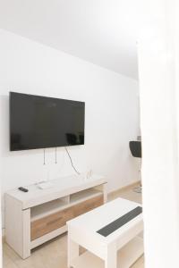 una sala de estar blanca con TV en una pared blanca en IKI White Playa La Arena, en Puerto de Santiago