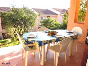 un tavolo con sedie e una tovaglia blu e gialla di Casa Vacanza Porto Corallo a Villaputzu