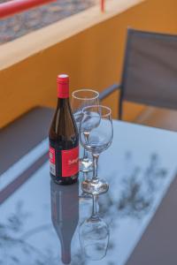 una botella de vino y dos copas de vino en una mesa en IKI White Playa La Arena, en Puerto de Santiago