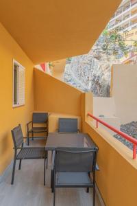 una habitación con 2 sillas y una mesa en un edificio en IKI White Playa La Arena, en Puerto de Santiago