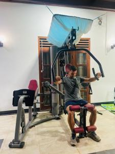 a man sitting in a chair in a gym at House of Richness in Negombo