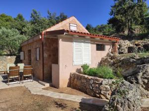 ein kleines Haus mit einem Tisch und Stühlen davor in der Unterkunft Mala oaza in Vrisnik