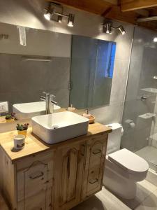 La salle de bains est pourvue d'un lavabo, de toilettes et d'un miroir. dans l'établissement Minicasa familiar con tina medicinal., à Urubamba