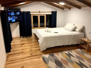 1 dormitorio con 1 cama grande y TV de pantalla plana en Minicasa familiar con tina medicinal. en Urubamba