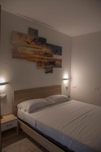 a bedroom with a bed and a painting on the wall at QUEEN appartamenti e camere in Campofilone