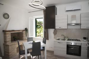 a kitchen with a table and a dining room with a fireplace at QUEEN appartamenti e camere in Campofilone
