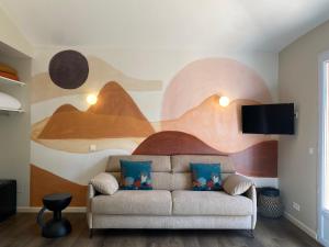 ein Wohnzimmer mit einem Sofa mit einem Gemälde an der Wand in der Unterkunft Hotel du Pont de l'Oso in Cala Rossa