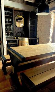 een eetkamer met een houten tafel en een bar bij Apartamentos UXAMA LUXURY EPONA - junto a la Plaza Mayor in El Burgo de Osma