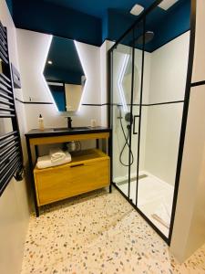 a bathroom with a shower and a mirror at Grand Hôtel Clichy Paris in Clichy